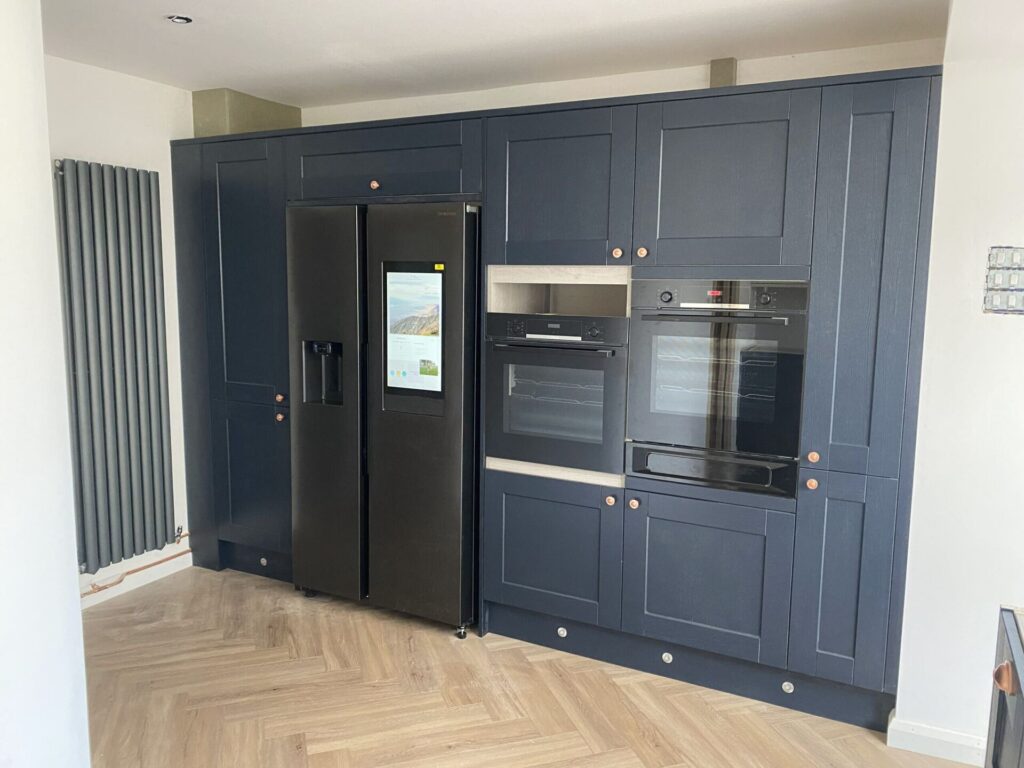 Built-in navy kitchen cabinetry with integrated appliances